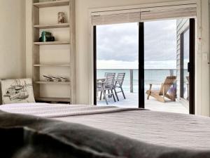 a bedroom with a bed and a view of the ocean at The Mariner - Oceanfront Living in Falmouth