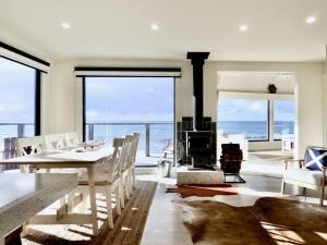 a dining room with a table and a fireplace at The Mariner - Oceanfront Living in Falmouth