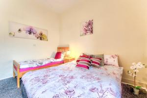 a bedroom with two beds with pink and purple sheets at Edinburgh Central Drumdryan ApartHotel in Edinburgh +21 photos