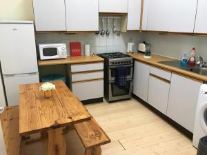 a kitchen with a wooden table and a stove at Edinburgh Central Drumdryan ApartHotel in Edinburgh