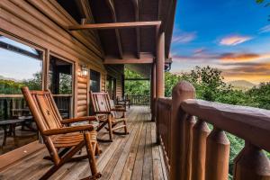 a porch of a log cabin with rocking chairs at Absolute Bearadise cabin in Sevierville