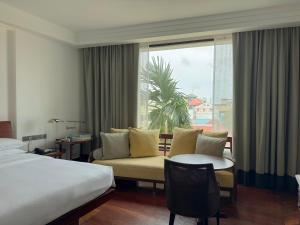 a hotel room with a bed and a couch and a window at Park Hyatt Siem Reap in Siem Reap