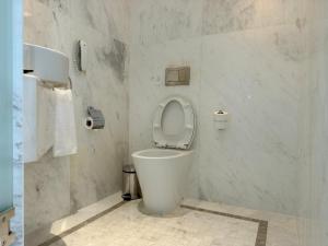 a white bathroom with a toilet with the seat up at Park Hyatt Siem Reap in Siem Reap +105 photos