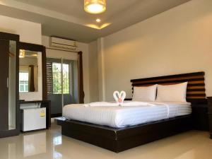 a bedroom with a large white bed with a rabbit on it at Baan Ing Daan in Ban Non Nam Thaeng