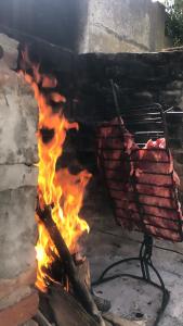a grill with a bunch of meat on fire at Quinta del Pinar in Azul