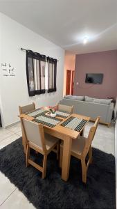 a wooden table and chairs in a living room at Doce Lar 3 in Pouso Alegre