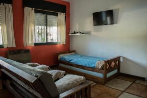 a room with two beds and a tv on the wall at Quinta del Pinar in Azul