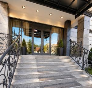 a staircase leading to a building with glass doors at Sara Hotel Bishkek in Bishkek