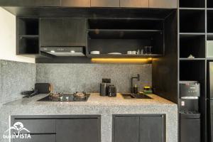 a kitchen with black cabinets and a counter top at Villa Lyma by Bukit Vista in Pererenan