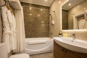 a bathroom with a tub and a sink and a shower at Sara Hotel Bishkek in Bishkek +29 photos