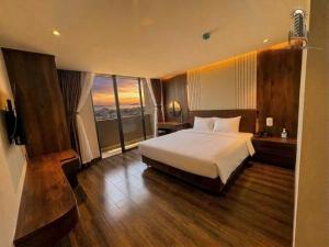 a hotel room with a bed and a large window at Thuỳ Dung 68 Hotel in Dong Hoi +8 photos