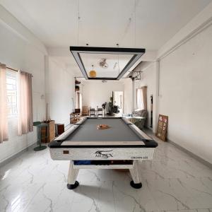 a ping pong table in a large living room with at Nhà của Buôn in Buon Ma Thuot