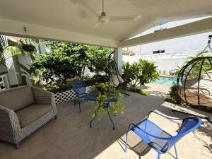 eine Terrasse mit Sofa und Stühlen und ein Pool in der Unterkunft Bellacozenza in Cabo San Lucas