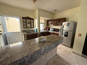 eine Küche mit Granitarbeitsplatte und Kühlschrank in der Unterkunft Bellacozenza in Cabo San Lucas