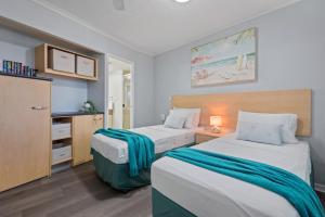 a hotel room with two beds and a cabinet at Moana Condo | Close to Beach in Caloundra