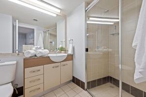 a bathroom with a toilet sink and a shower at Moana Condo | Close to Beach in Caloundra +18 photos