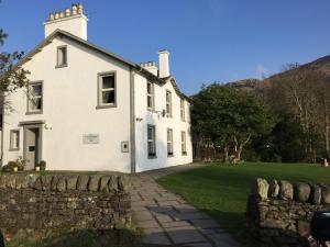 a large white house with a stone wall at The Shore House in Lochgoilhead