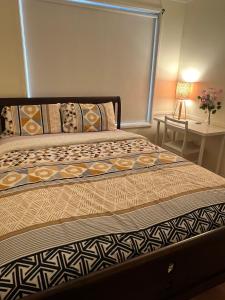 a large bed in a bedroom with a table at Private Rm3A in Elderslie in Elderslie