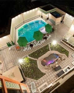 an overhead view of a swimming pool with chairs and umbrellas at Hotel Gold Begim in Fergana