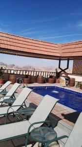 une rangée de chaises longues et une piscine dans l'établissement P Quattro Relax Hotel, à Wadi Musa