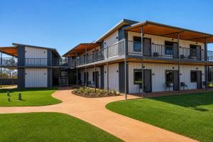 a building with balconies and a lawn in front of it at Oasis Newman in Newman