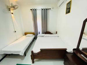a bedroom with two beds and a piano at Hotel Kandy Village Inn in Kandy