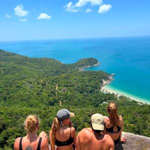 a group of people sitting on top of a rock overlooking the ocean at Lingling Hostel in Haad Rin