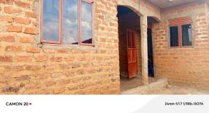 a brick wall with a door and a window at Ebenezer Community Development Center in Rubanda
