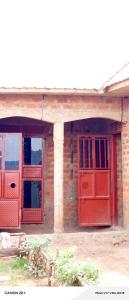 a brick house with red doors and windows at Ebenezer Community Development Center in Rubanda