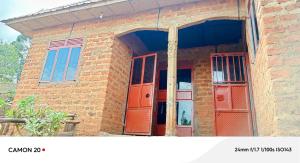 a brick building with an open door and windows at Ebenezer Community Development Center in Rubanda
