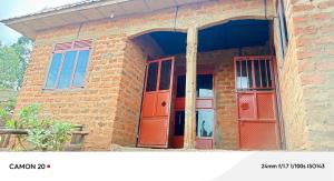 a brick building with red doors and windows at Ebenezer Community Development Center in Rubanda