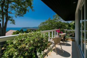 a balcony with two chairs and a view of the ocean at Katamanda Villa Jade A6 Seaview Kata Beach in Kata Beach
