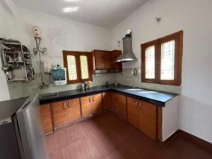 a kitchen with wooden cabinets and a black counter top at LRX Retreats in Chaubattia