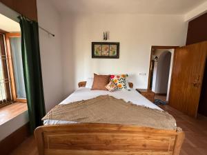a bedroom with a wooden bed with a green canopy at LRX Retreats in Chaubattia +2 photos