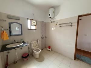a bathroom with a toilet and a sink and a mirror at LRX Retreats in Chaubattia