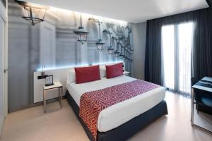 een slaapkamer met een groot bed met rode kussens bij Catalonia Avinyo in Barcelona