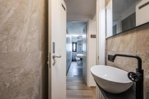 a bathroom with a white sink and a toilet at Maserati House - H24 in Modena +28 photos