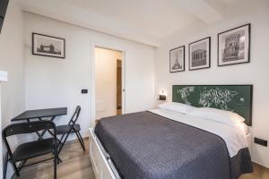 a bedroom with a bed and a desk and a chair at Maserati House - H24 in Modena