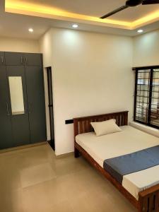a bedroom with a bed and a window at Hotel Grand Illam in Ernakulam