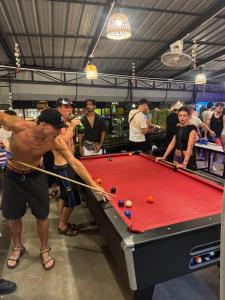 a man playing a game of pool with a stick at Lingling Hostel in Haad Rin