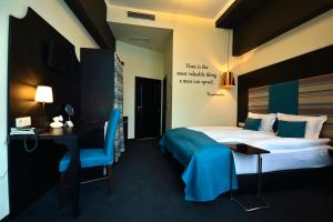 una camera d'albergo con letto, scrivania di City Art Boutique Hotel a Ruse