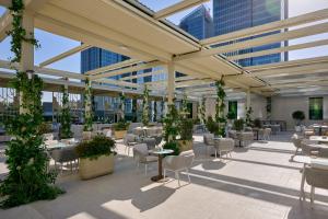 a cafeteria with tables and chairs in a building at Hilton Tashkent City in Tashkent