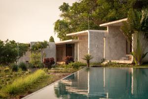 a house with a swimming pool in front of it at La Plantation Villa in Kampot