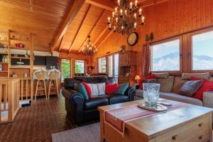 a living room with couches and a table in a house at Chalet Belle Poncke by Jolidi in Nendaz