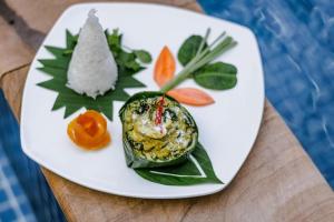 a white plate with food on a table at Raksmey Angkor Boutique in Siem Reap