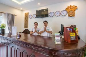 two men standing behind a counter with their hands at Raksmey Angkor Boutique in Siem Reap +26 photos