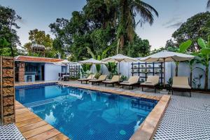 a swimming pool with lounge chairs and umbrellas at Raksmey Angkor Boutique in Siem Reap