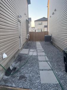 a driveway with a green hose next to a building at Peniel Place in Airdrie