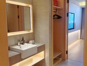 a bathroom with a sink and a mirror at JI Hotel Hangzhou Banshan Road in Hangzhou +27 photos