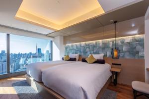 a bedroom with a large bed and a large window at THE BLOSSOM HIBIYA in Tokyo